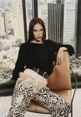 Camisa negra de manga larga con volados frontales y en las mangas, confeccionada en tela ligera y fluida.