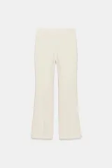 Pantalón de tiro alto con diseño cropped, confeccionado en tejido con viscosa. Presenta raya planchada frontal, aberturas laterales en el bajo y cierre lateral con cremallera oculta.