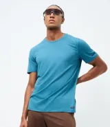 Remera deportiva de hombre con tecnología dry fit, cuello redondo y mangas cortas. Presenta un diseño minimalista con etiqueta aplicada en el dobladillo y detalles a contraste.