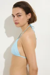 Top de bikini celeste con diseño triangular, copas plisadas y tiras finas para atar en el cuello y la espalda.