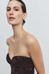 Corsé de encaje negro con escote corazón, hombros descubiertos y varillas interiores para estructura. Cuenta con cierre lateral mediante cremallera oculta.