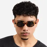 Lentes de sol con armazón de carey en tonos marrones y forma ovalada, con cristales oscuros y protección UV400.