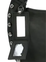 Cartera tipo hobo de la marca Hush Puppies, color negro, con diseño de asa única integrada y detalle de tachas metálicas en los laterales y la base. Incluye un colgante decorativo con el logo de la marca.