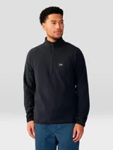 Buzo de polar con cierre frontal de 1/4, cuello alto y mangas raglán. Presenta un diseño minimalista en color negro con el logo de la marca bordado en el pecho.