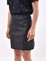 Minifalda negra de cuero sintético, corte recto y abertura frontal.