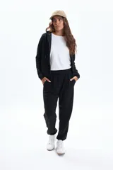 Pantalón deportivo negro de corte holgado con puños ajustados en los tobillos y cordón de ajuste en la cintura.