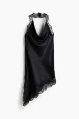 Vestido corto de satén color negro, con escote drapeado, espalda descubierta y breteles halter de encaje. Presenta bajo asimétrico con detalles de encaje.