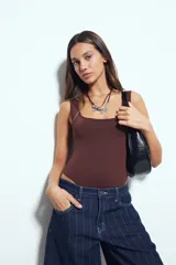 Body negro de escote cuadrado y silueta ajustada al cuerpo, sin mangas, con terminaciones prolijas en escote y sisas.