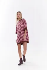 Vestido corto de tejido de punto con diseño de rayas horizontales en tonos rojo y rosado, con detalles en color marrón en el cuello, puños y ruedo. Presenta un ajuste relajado, mangas cortas y detalle de bordado frontal.