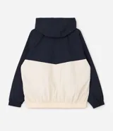 Campera cortavientos deportiva de Ashua, con diseño bicolor en negro y blanco. Presenta capucha integrada ajustable, cierre frontal con cremallera, mangas largas con puños elásticos y cintura elástica. Confeccionada en poliamida con forro de poliéster.