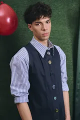 Mono largo de color negro con cierre frontal de botones vintage de distintos colores. Presenta un diseño sin mangas, con bolsillos laterales y una cinta para herramientas en la parte trasera.