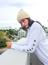 Remera de manga larga color blanco, con estampado frontal con la frase 'Style Club' y estrellas pequeñas en las mangas.