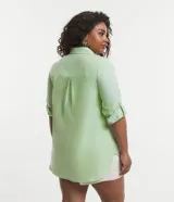 Camisa de tricolina color verde claro, con cuello inglés, mangas largas con trabilla para sujetar y botones delanteros.