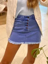 Minifalda de jean azul con botones frontales y ruedo desflecado.
