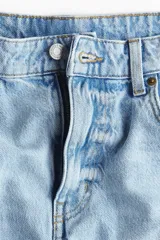 Jean tobillero de cinco bolsillos en denim de algodón rígido, con diseño curvo y volumen en las piernas de tiro alto.