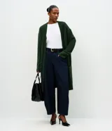 Cardigan largo de punto con textura de pelos, color negro, con mangas largas y bolsillos frontales. Diseño abierto y versátil de la marca Cortelle.