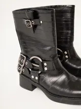 Botas cortas de cuero marrón con textura, hebillas ajustables, apliques circulares y punta cuadrada.