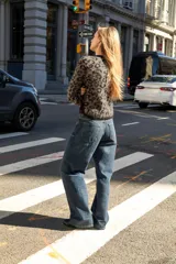 Chaqueta abierta de punto con cuello redondo y manga larga. Presenta un diseño de jacquard con estampado animal y detalles de ribetes en color negro en cuello, puños y borde frontal.