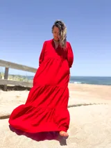 Vestido largo color rojo, con escote en V, mangas 3/4 abullonadas y corte escalonado con volantes.