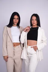 Blazer negro levemente largo, con solapas de muesca, doble botonadura con botones metálicos dorados, hombreras y bolsillos delanteros ribeteados con solapa.