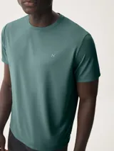 Camiseta deportiva azul marino de manga corta y cuello redondo, con un pequeño logo blanco bordado en el pecho.