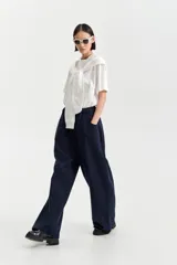 Camiseta blanca de manga corta con un buzo blanco de manga larga cosido en la parte superior, creando un efecto de prenda superpuesta atada al cuello.