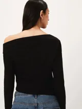 Blusa negra de manga larga con diseño asimétrico en el escote, dejando un hombro al descubierto. Presenta un corte ajustado con detalle de frunces laterales que crean un efecto drapeado en el torso.