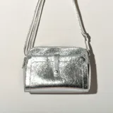Bandolera plateada de cuero sintético con correa larga regulable.