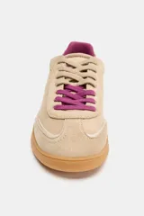 Zapatilla deportiva de gamuza en color beige, con cordones y forro interior en color fucsia, montada sobre una suela de goma color caramelo.