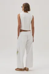 Pantalón barrel color crudo en gabardina 100% algodón, con bordados decorativos en ambas piernas.