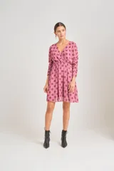 Vestido corto de gasa rosada con estampado de lunares en tonos terracota, escote en V cruzado y corte en la cintura.