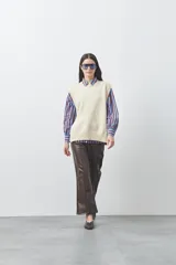Chaleco tejido de punto con silueta relajada y diseño sin mangas. Presenta lazos laterales ajustables y cuello redondo.