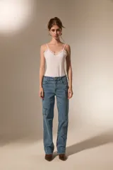 Body de breteles finos color blanco, con escote en V y detalle de encaje en el borde superior. Confeccionado en poliéster, presenta un diseño ajustado al cuerpo con cierre de broches en la parte inferior.