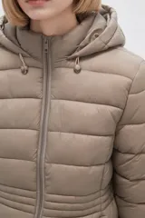 Campera acolchada color beige, de corte largo, con capucha y cierre frontal con cremallera.