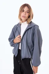 Campera corta impermeable con capucha, cierre frontal completo y puños elásticos.