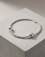 Pulsera de plata 925 compuesta por pequeñas cuentas esféricas y una cuenta central de mayor tamaño.