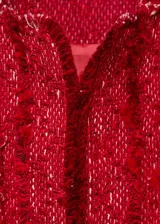 Chaqueta de tweed color rojo, de diseño recto, cuello redondo y manga larga. Cuenta con terminaciones deshilachadas y cuatro bolsillos de parche delanteros.