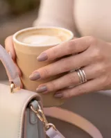 Anillo triple de acero quirúrgico color plateado, compuesto por tres aros finos unidos, uno de ellos con textura granulada y detalles de circón.
