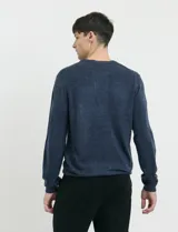 Sweater de tejido de punto con escote redondo y manga larga, con detalles de costuras en sisas y cuello. Presenta un diseño clásico y versátil.
