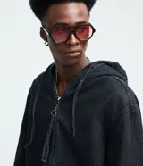 Campera tipo bomber confeccionada en tejido de jean, con cierre frontal de cremallera, capucha ajustable con cordones y bolsillos frontales. Presenta puños y cintura elásticos, ofreciendo un ajuste cómodo y un estilo urbano.