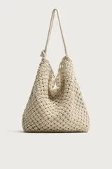 Bolso de hombro confeccionado en tejido trenzado de algodón con diseño de macramé, asa de hombro con detalle de nudo y bolsillo interior plano.