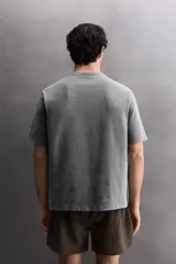 Camiseta de corte regular fit confeccionada en algodón, con cuello redondo y manga corta. Presenta un estampado frontal con el texto 'ATHLETICZ TRAINING CREW' con efecto desgastado.