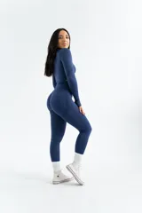 Remera deportiva de manga larga, confeccionada en tejido técnico elástico de color gris oscuro, con diseño ajustado al cuerpo y cuello redondo.