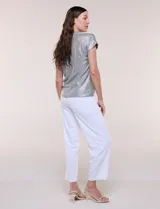 Blusa de tejido metalizado plateado con textura acanalada, escote en V y mangas corta con hombros caídos de calce fluido.