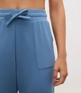 Pantalón tipo jogger de mujer, confeccionado en tejido modal con mezcla de poliéster y elastano. Presenta cintura elástica con lazo de ajuste, bolsillos laterales y puños elásticos en el ruedo.