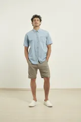 Camisa de jean celeste de manga corta con cuello abotonado y bolsillo en el pecho.