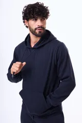 Buzo con capucha y bolsillo frontal tipo canguro, confeccionado en tela de felpa, con cordones ajustables en el cuello y puños elásticos.