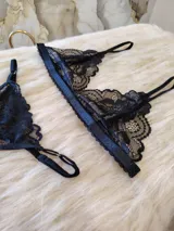 Conjunto de lencería compuesto por un bralette de encaje negro con breteles regulables y una tanga regulable con corte cola less y entrepierna de algodón.