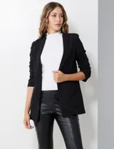 Blazer de crepe de la marca BBJ, color negro, con cuello solapa, bolsillos delanteros y mangas tres cuartos con frunce. Cuenta con forro interno.