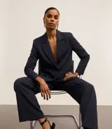 Pantalón de vestir azul marino, de corte wide leg, con cintura alta, pliegues frontales, bolsillos laterales y aplicación de strass.